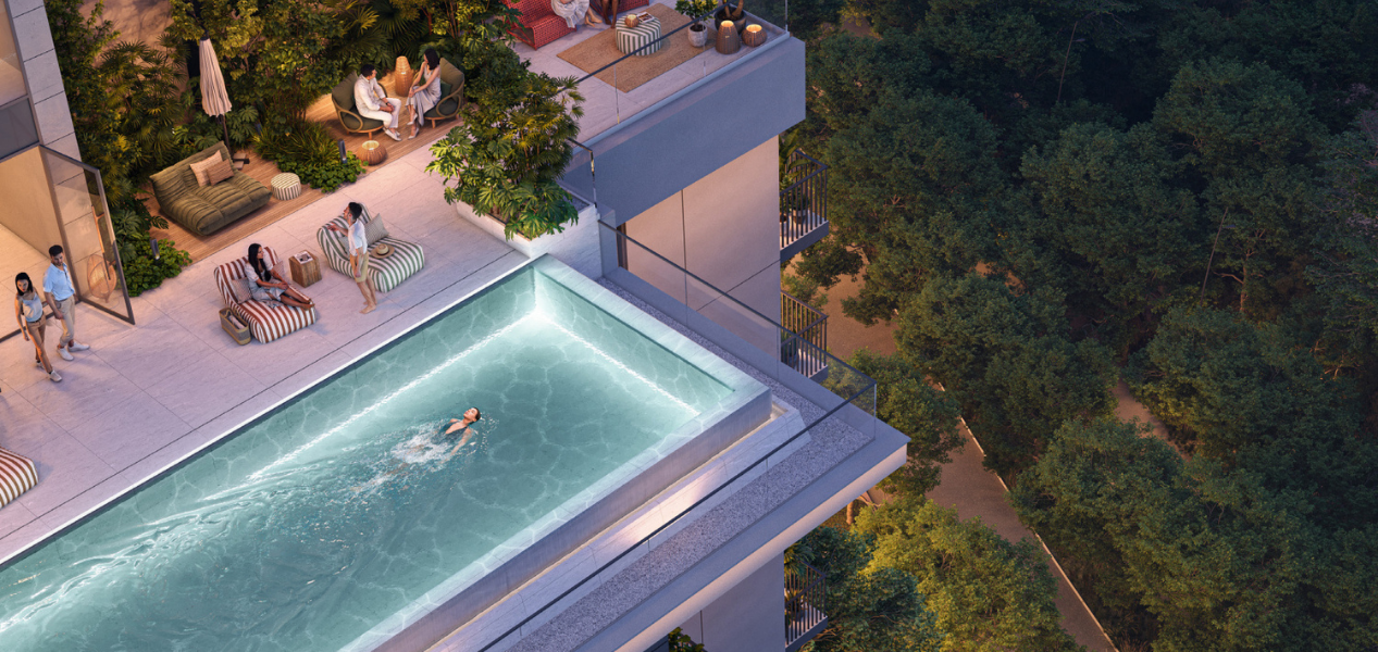 Rooftop pool and leisure area at DISTRIKT at Ghaf Woods surrounded by trees