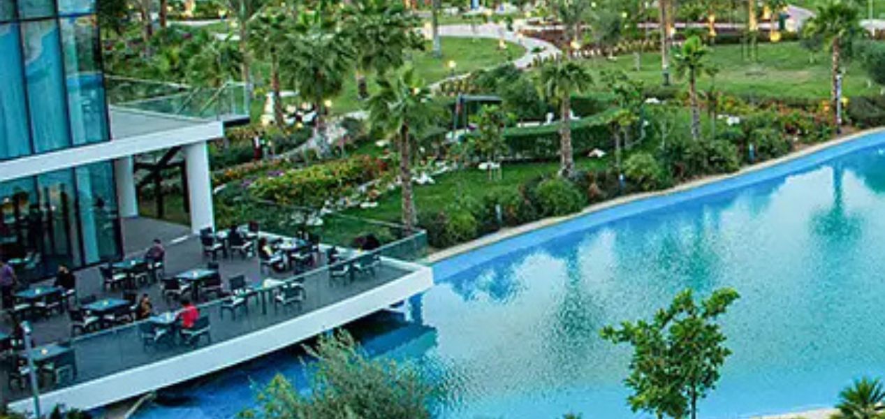 Poolside dining and green park area at Camelia Villas Damac Hills