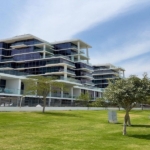 2‑bedroom Golf Greens apartment exterior with landscaped lawn and walking path