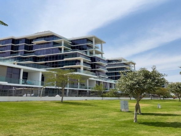 2‑bedroom Golf Greens apartment exterior with landscaped lawn and walking path